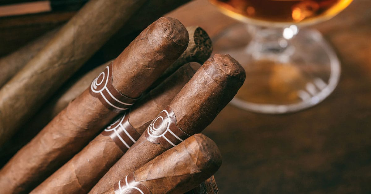 stack-of-cigars-next-to-whiskey-glass